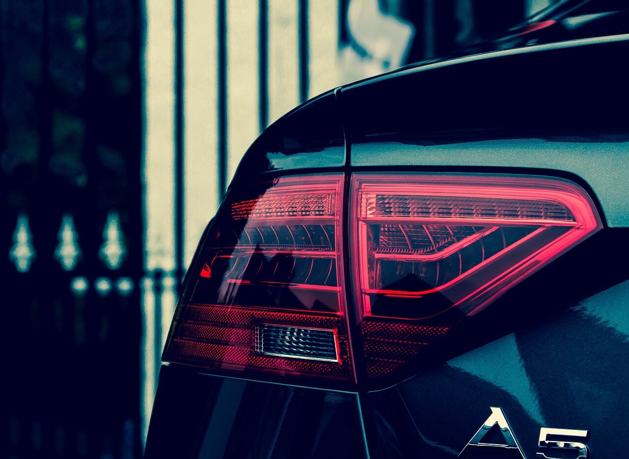 Audi A5 parked next to a fence