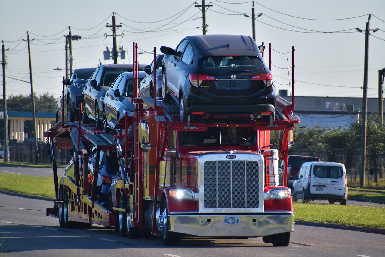 red car trailer carrying cars