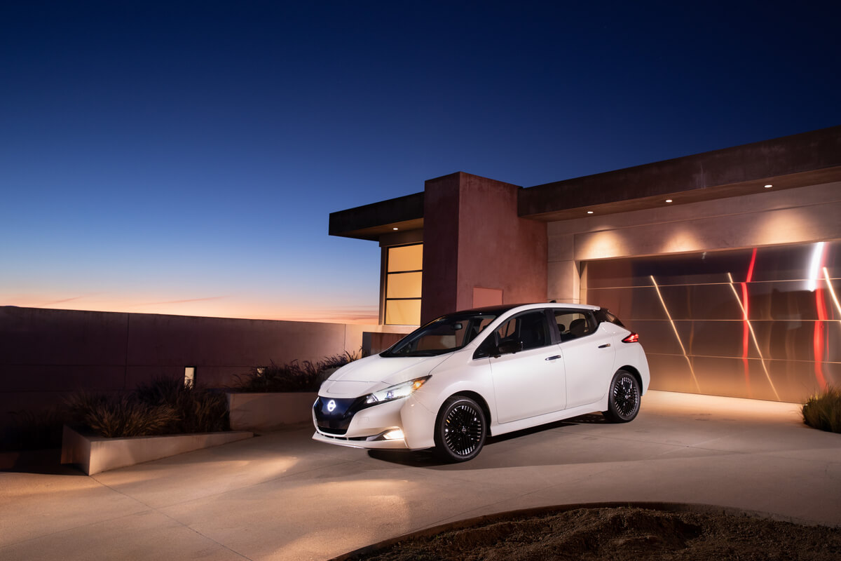 white car nissan leaf in front of a house