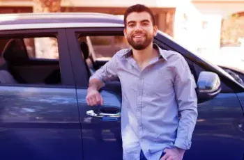 Man who leaned next to a blue car 