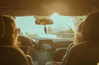 women driving a car into the sunset