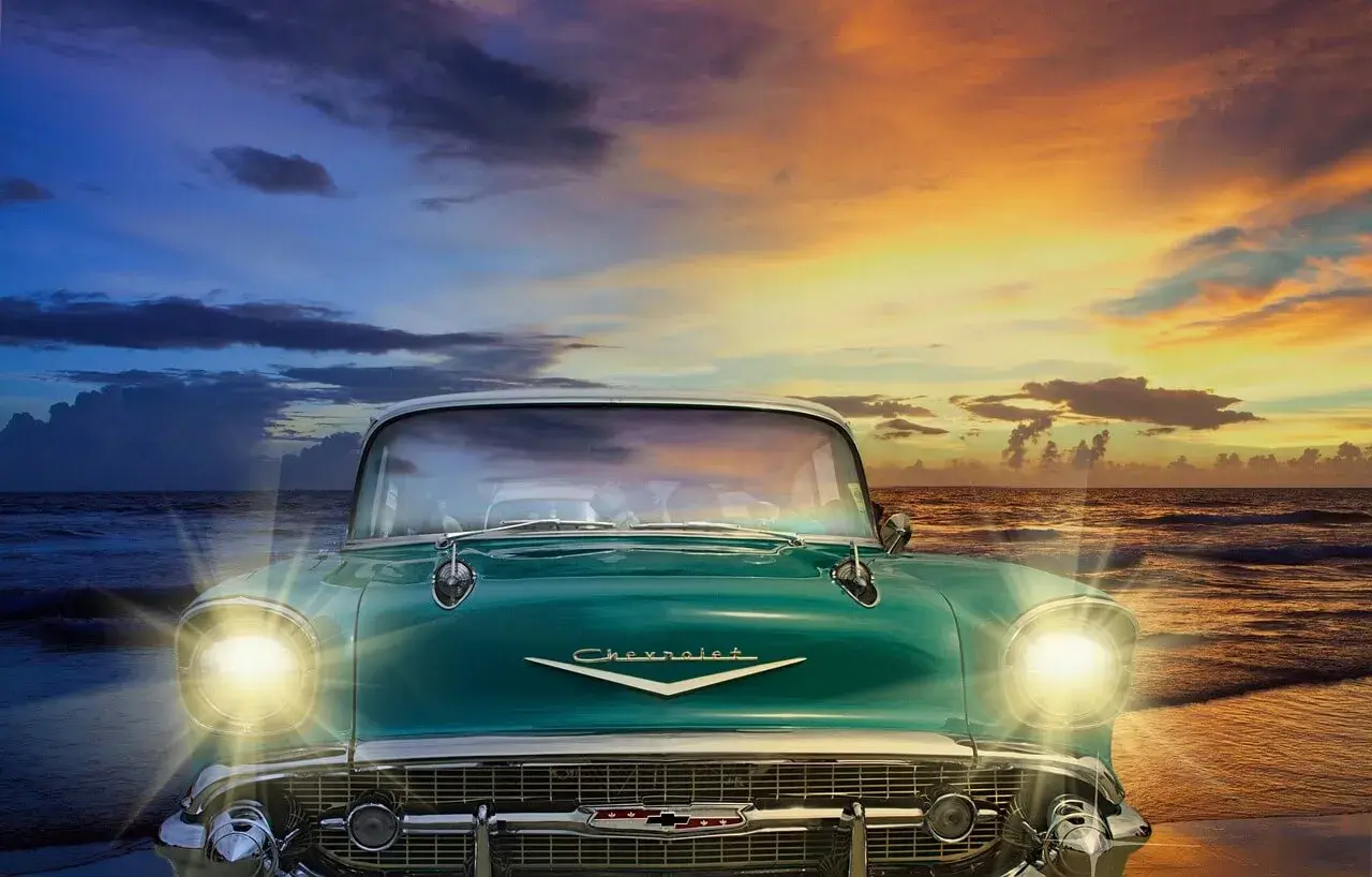 A blue Chevrolet and a sunset behind it