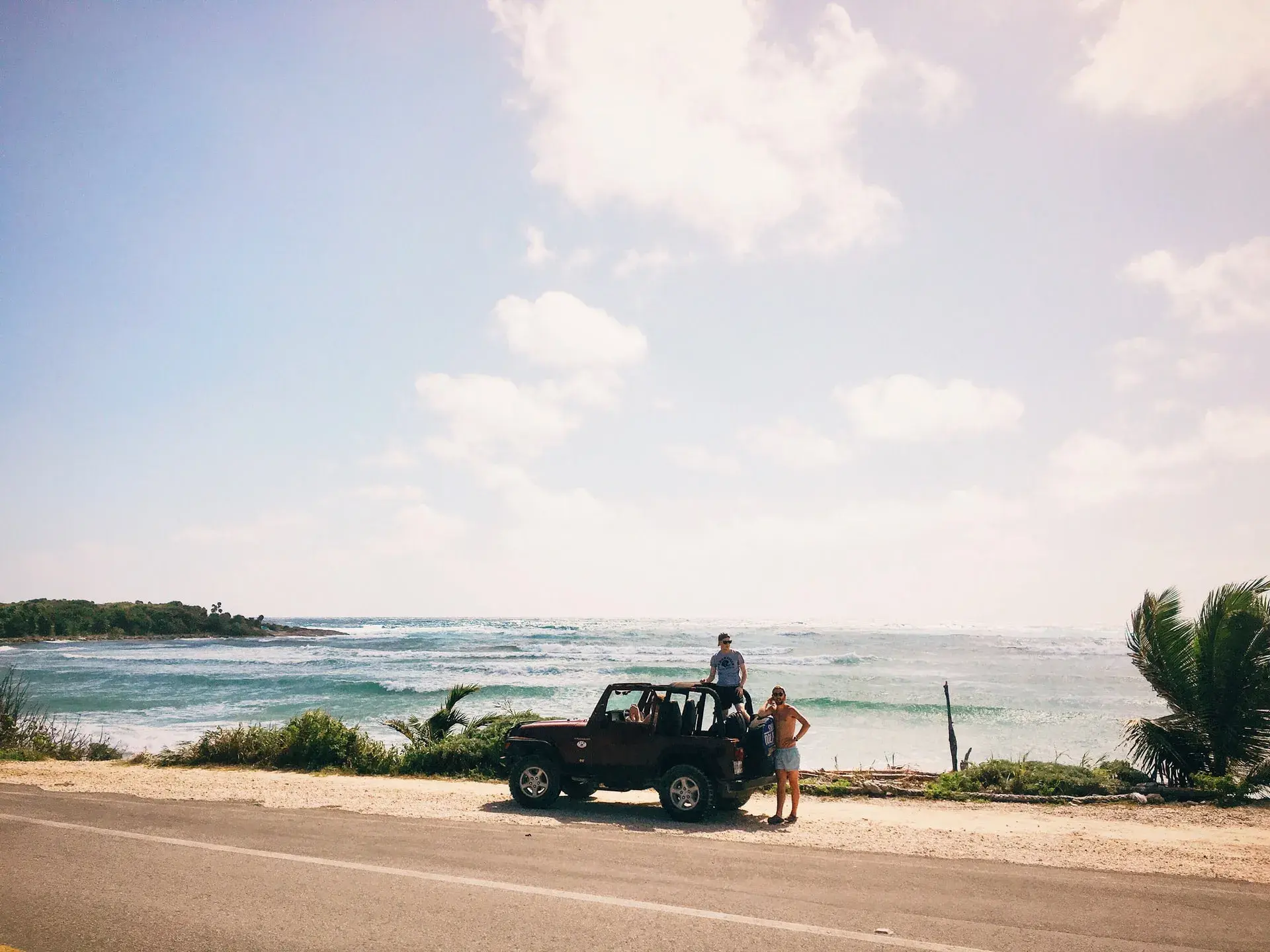 People in a car by the ocean in Hawaii