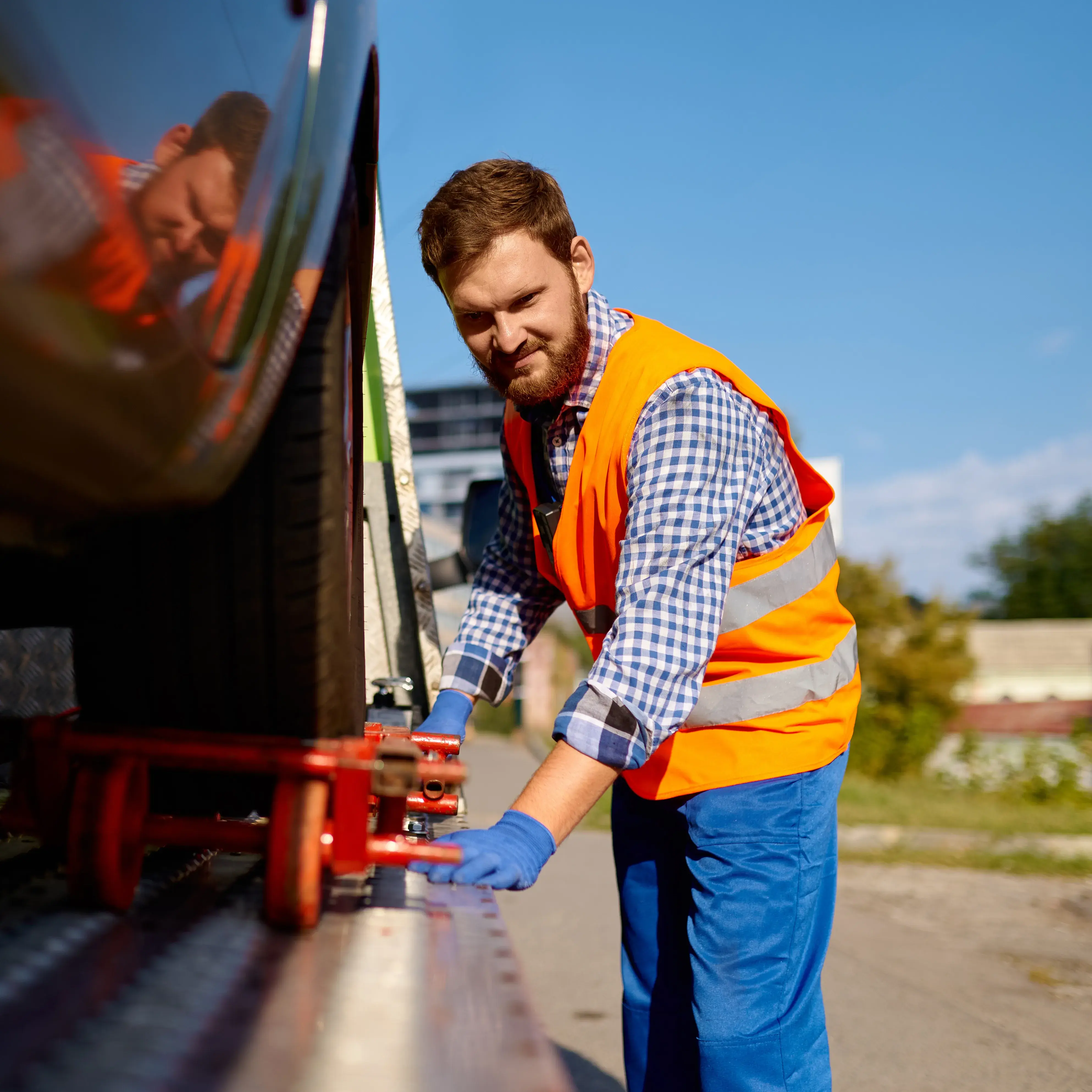 Man securing a vehicle onto a truck