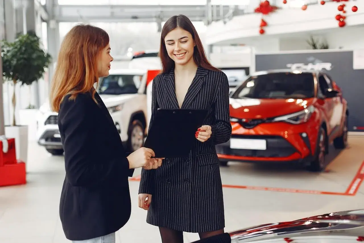 Woman tlaking to a car dealer